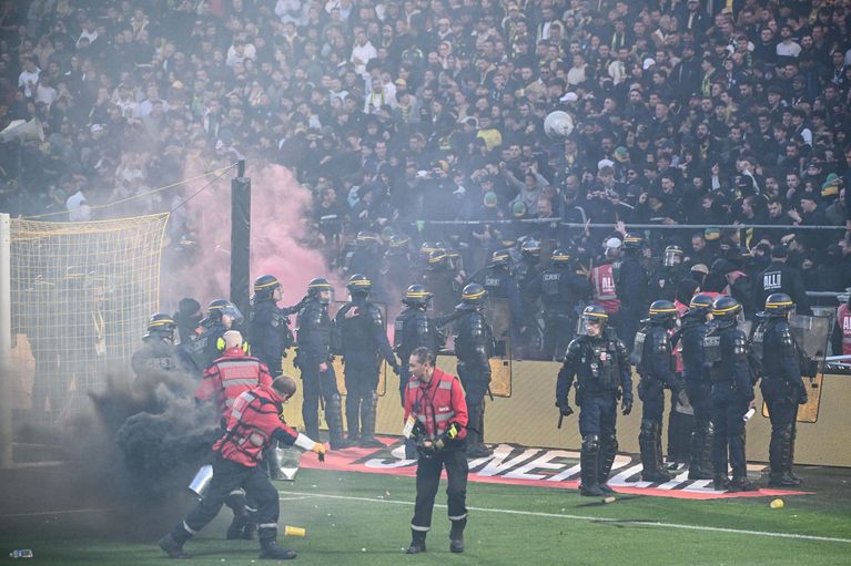 Les supporters nantais quittent la pelouse sous surveillance policière après l'interruption du match