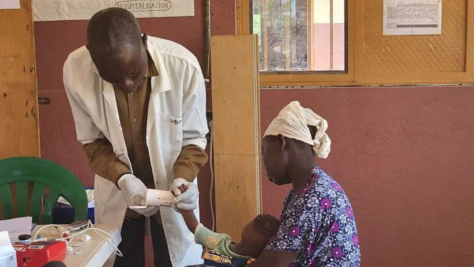 Médecin examine un enfant pour le paludisme dans un centre de santé du Nord-Kivu