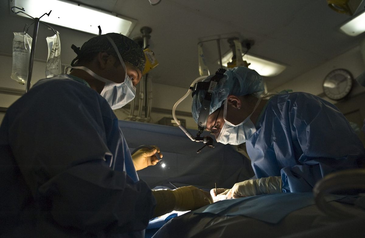 médecin en blouse devant un bloc opératoire