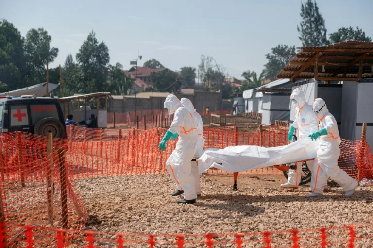 Un agent de santé en combinaison de protection manipule des échantillons lors d'une épidémie d'Ebola en RDC